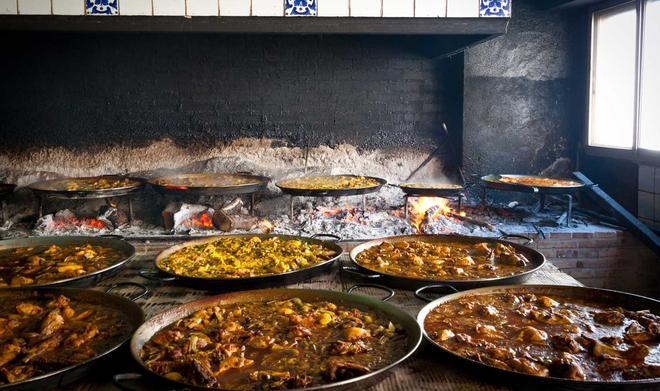 Valencian paella cooking on log fire