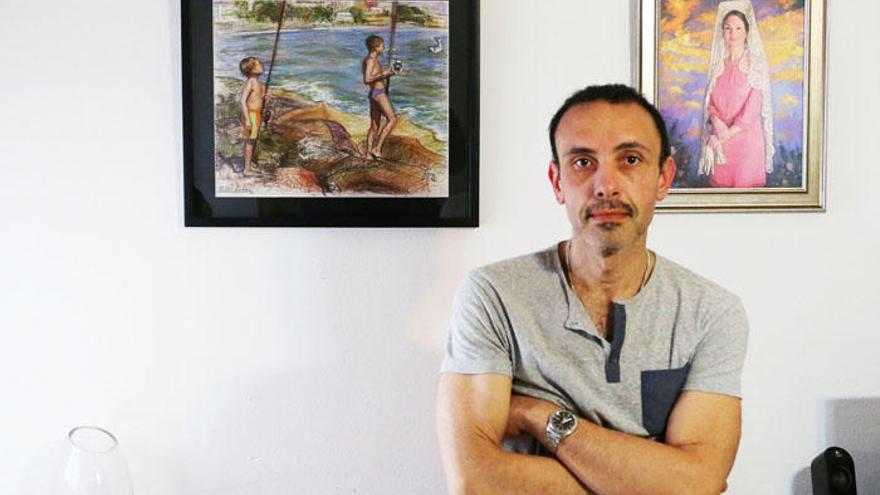 Cristóbal Córdoba, en su taller, delante de un dibujo de la playa de Pedregalejo y el retrato de Celia Flores.