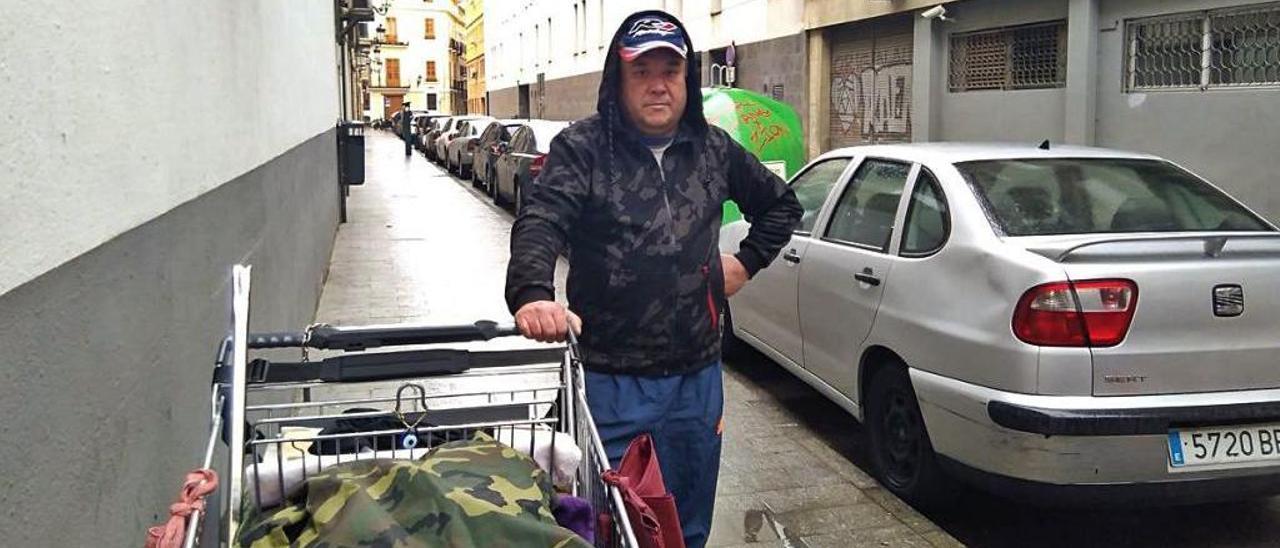 Mitch posa con el carro con el que recoge ropa de los contenedores, una ruta que le permite conocer la ciudad.