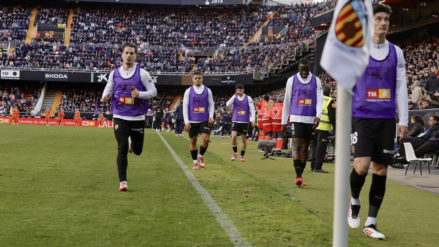 Los suplentes del Valencia CF calientan durante un encuentro de esta temporada en Mestalla.