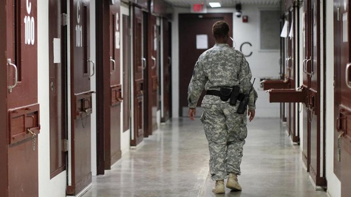 Un guardia camina entre los pasillos de una celda de Guantánamo.