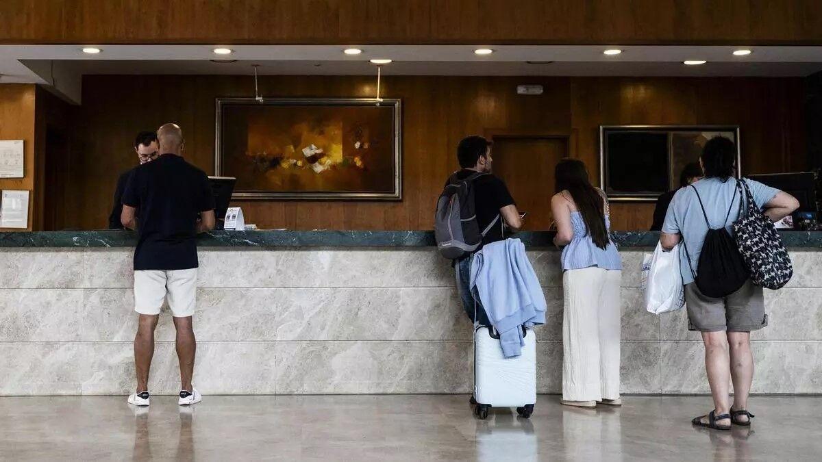 Varios clientes haciendo el registro a su llegada a un hotel para pasar las vacaciones en Canarias