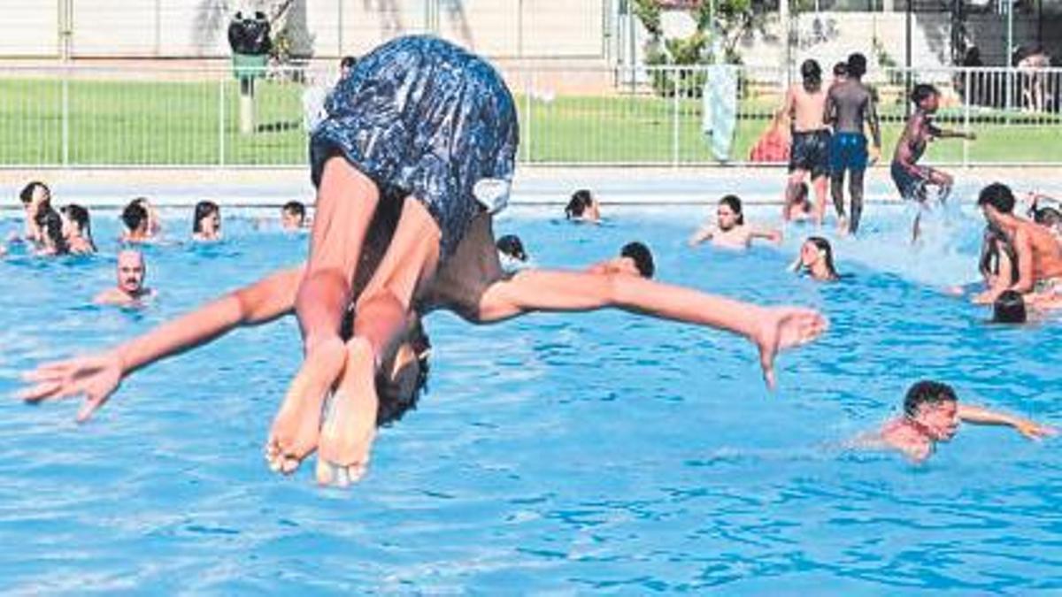 Un joven se zambulle de cabeza en el interior de una piscina.