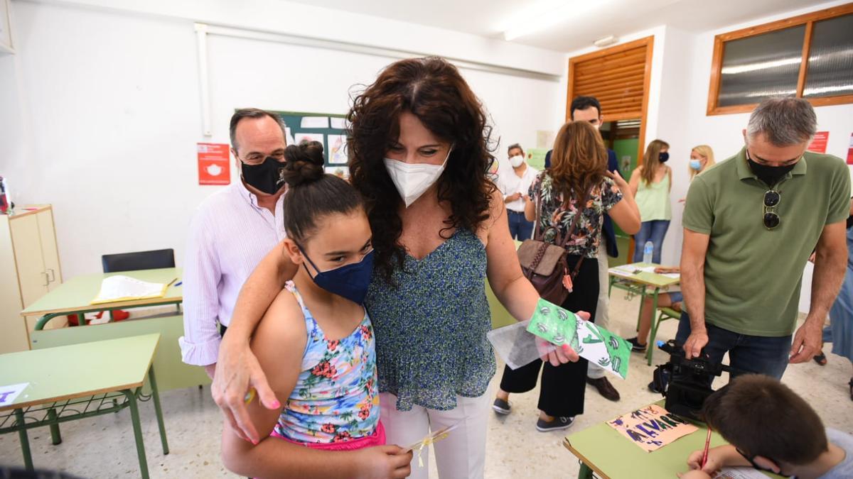 La consejera de  Igualdad, Rocío Ruiz, abraza a una niña de la escuela de verano del colegio Federico García Lorca