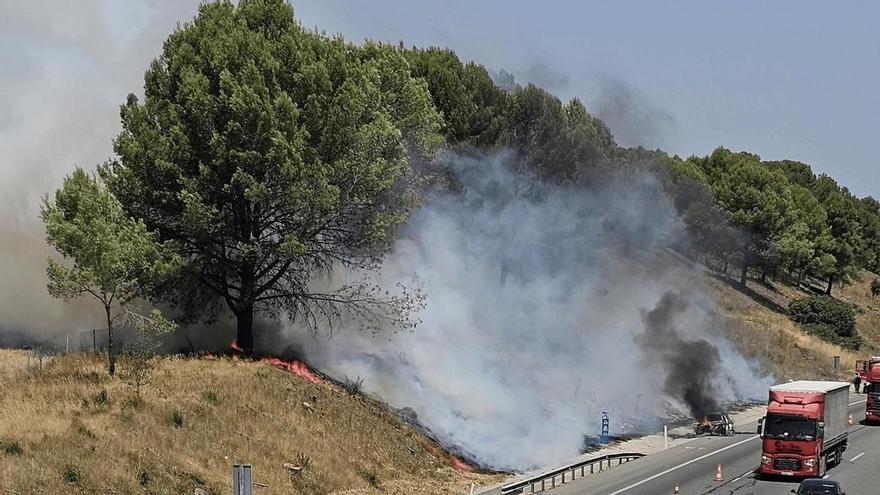 Un cotxe s'incendia a l'AP-7 a Bàscara i el foc salta fora de l'autopista