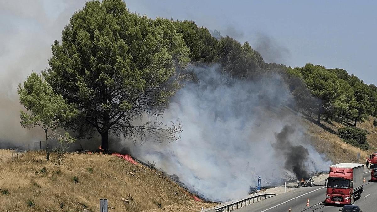L'incendi del vehicle i dels marges de l'autopista AP-7 a Bàscara.