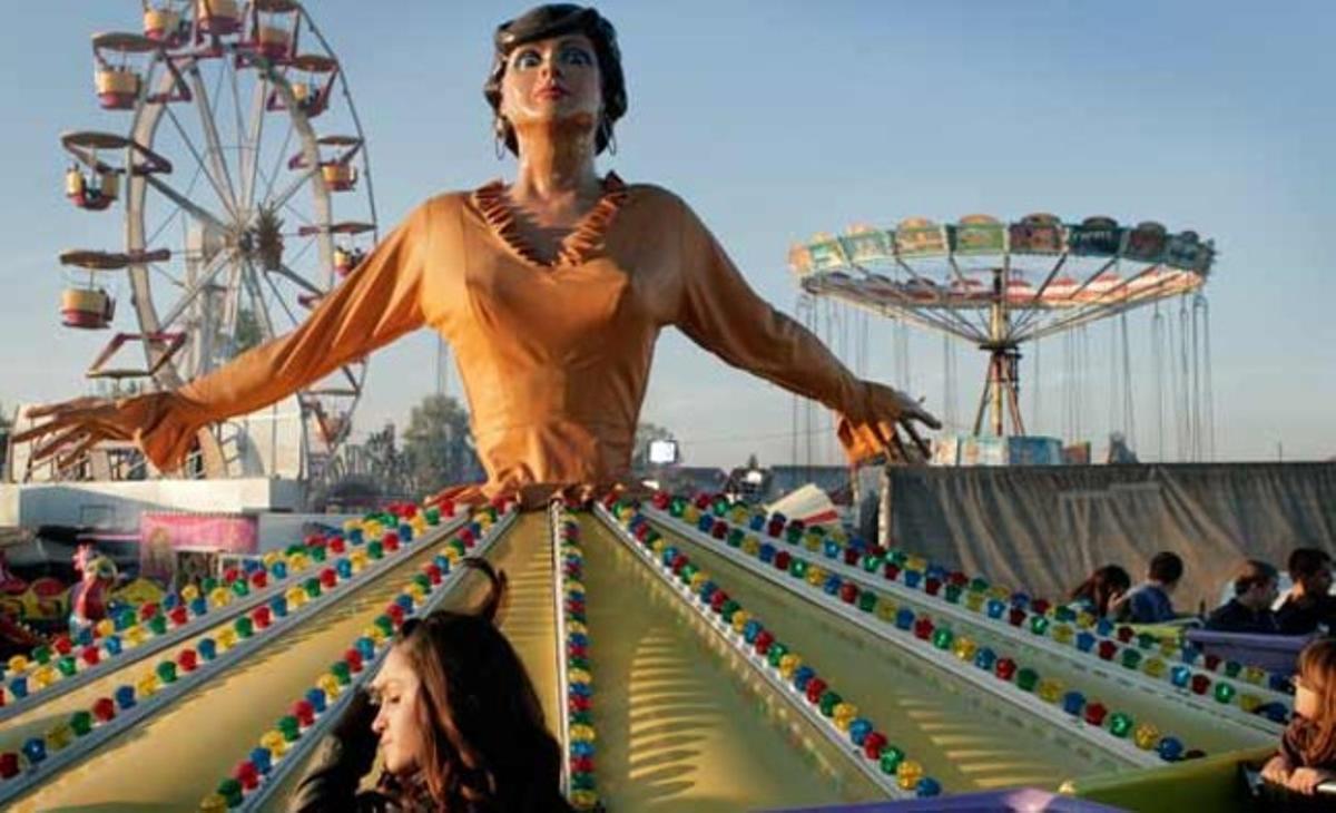 Una noia espera el seu torn per pujar a una atracció de fira, al poble romanès de Bolintin.