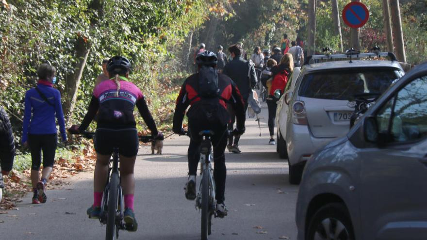 L&#039;inici d&#039;uns dels camins que porta al Castell de Sant Miquel amb cotxes, bicis i gent caminant aquest diumenge