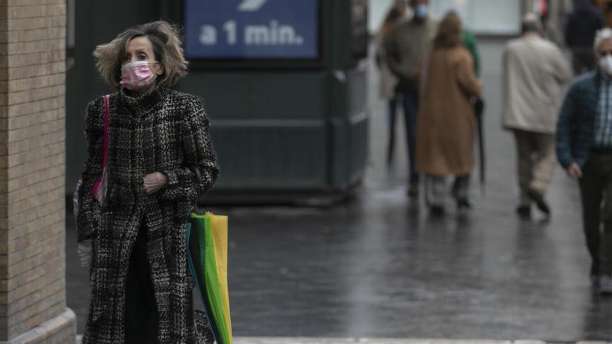 Una mujer con mascarilla pasea por el centro de Sevilla