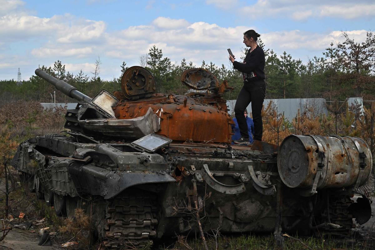 Una mujer fotografía un tanque ruso destruido en la región de Kiev, el 24 de abril de 2022.