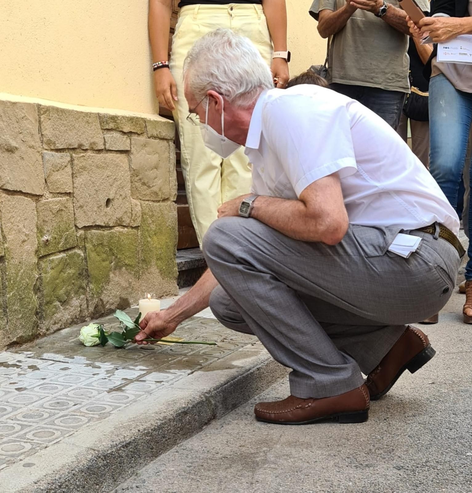 Fill de Bonifaci Servitja deixant flors a la llamborda stolpersteine que retrà homenatge al veí del municipi reportat