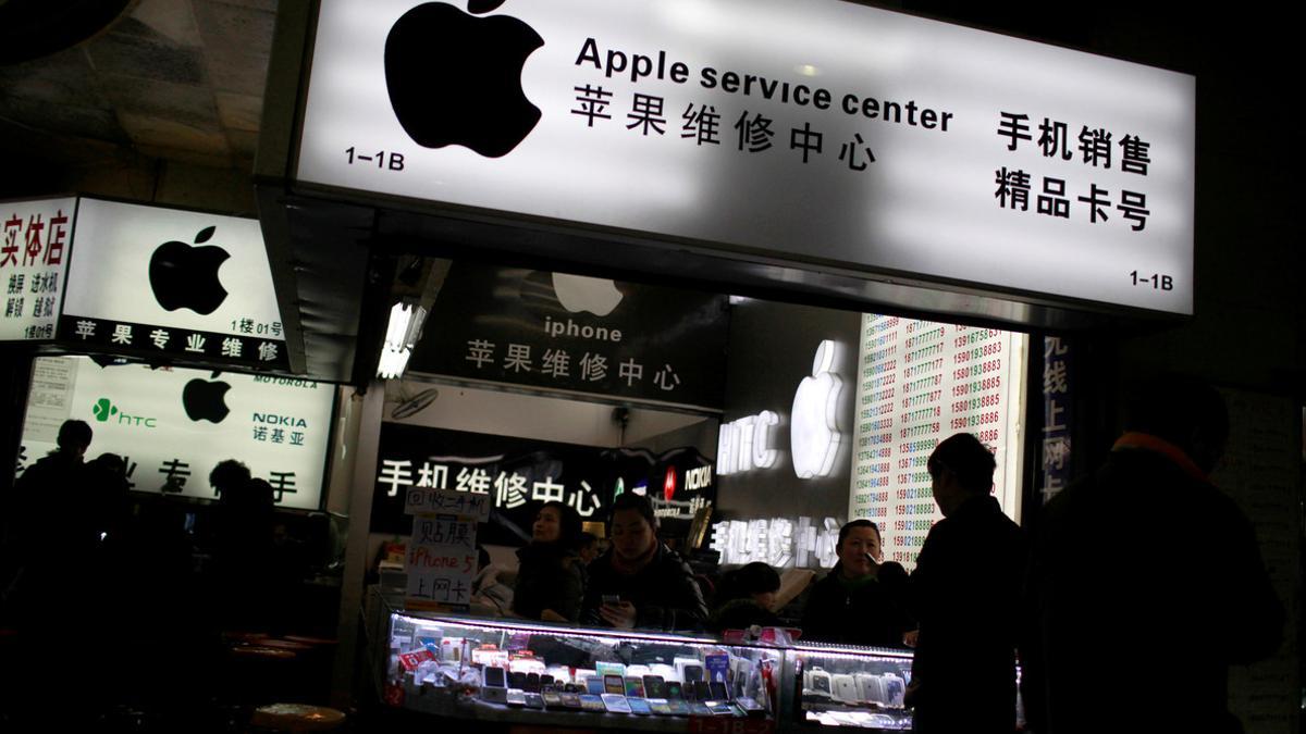 FILE PHOTO: Customers and sales persons are seen at an Apple maintenance service store at a mobile phone market in Shanghai