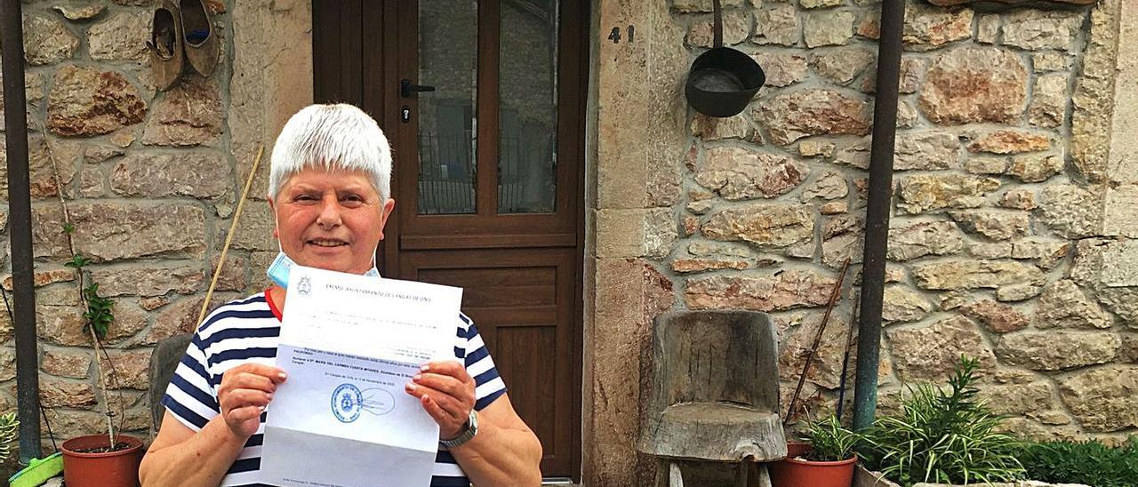 Carmen Cuesta, con el documento emitido por el alcalde de Cangas de Onís, José Manuel González. | M. V.