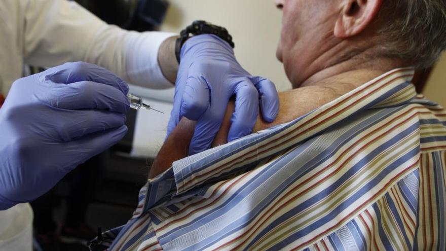 Un hombre mayor recibe la vacuna de la gripe. // A.G.