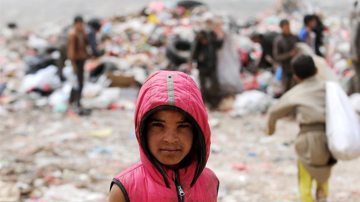 Un niño busca comida o cosas que se puedan vender en un vertedero en la capital yemení Saná