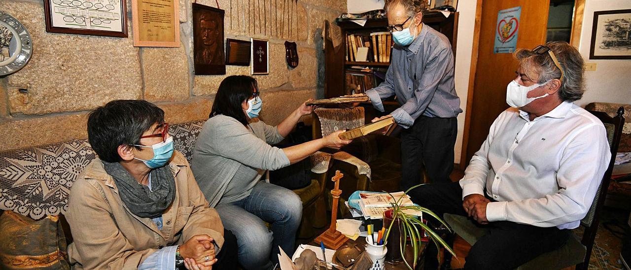 El arcipreste de O Lérez, Vicente Cerdeiriña, muestra libros parroquiales de San Salvador de Poio a las historiadoras. |  // GUSTAVO SANTOS