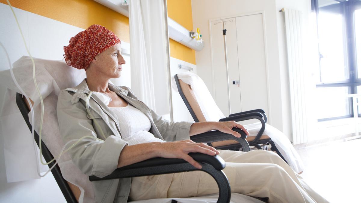 Paciente de cáncer sentada frente a la ventana del hospital.