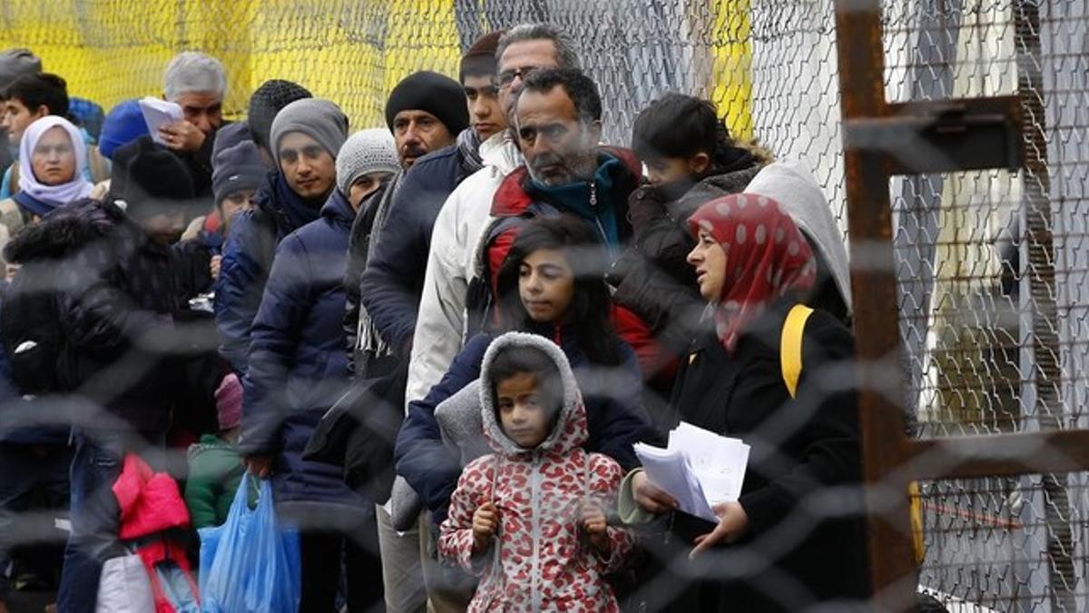 Refugiados esperando para cruzar la frontera de Eslovenia a Austria.