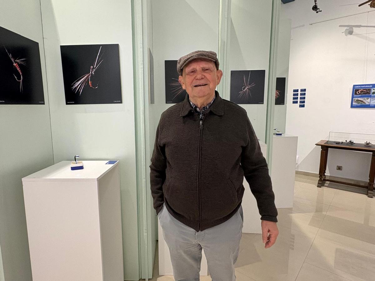 Benito Corolo en la exposición sobre la pesca, con las imágenes de su colección de moscas detrás.