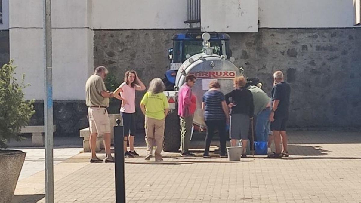 Vecinos en torno al camión cisterna en Ribadelago. | Araceli Saavedra