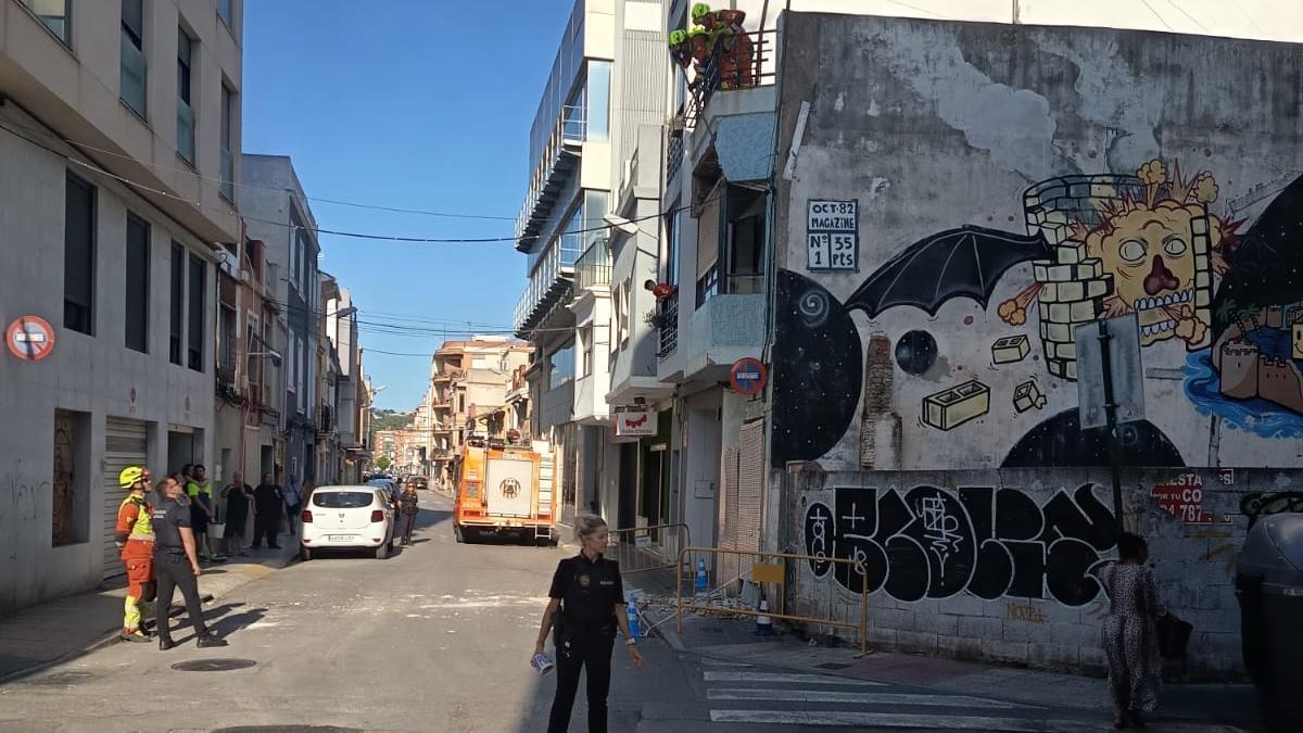 Los bomberos sanean la fachada mientras la Policía Local contra el tráfico, esta tarde, en la calle Colmenar.
