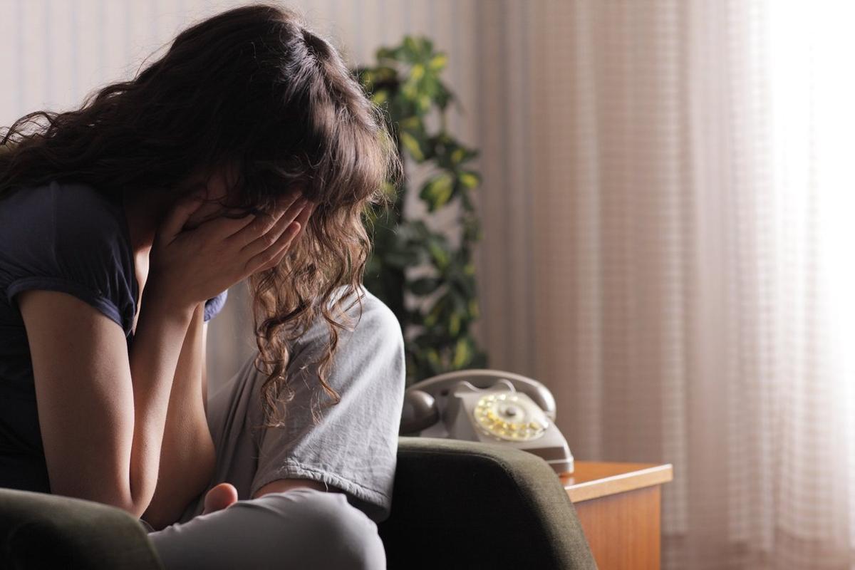 Mujer llorando en el sofá.