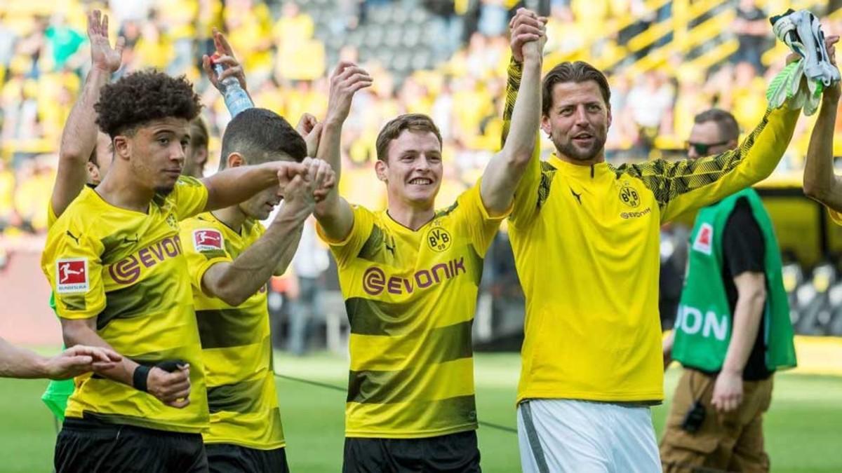Sergio Gómez saluda a la afición del Dortmund mientras recibe la felicitación de sus compañeros
