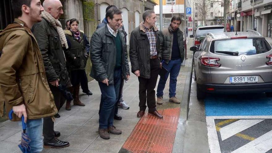 Bará, ayer con los vecinos, en la travesía de A Eiriña, con el viejo cuartel al fondo. // R. Vázquez