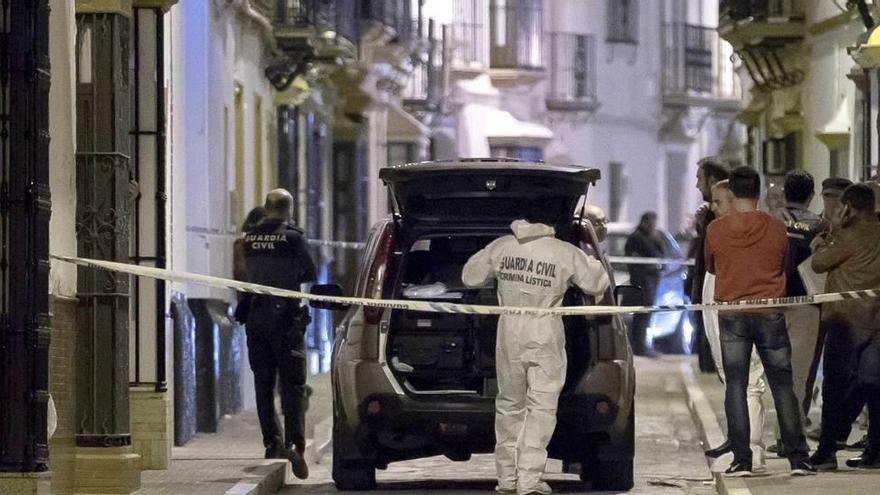 Agentes a la puerta de la casa donde se produjo el crimen.