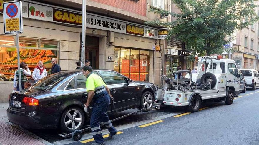 La grúa retira un vehículo estacionado en carga y descarga. // Rafa Vázquez