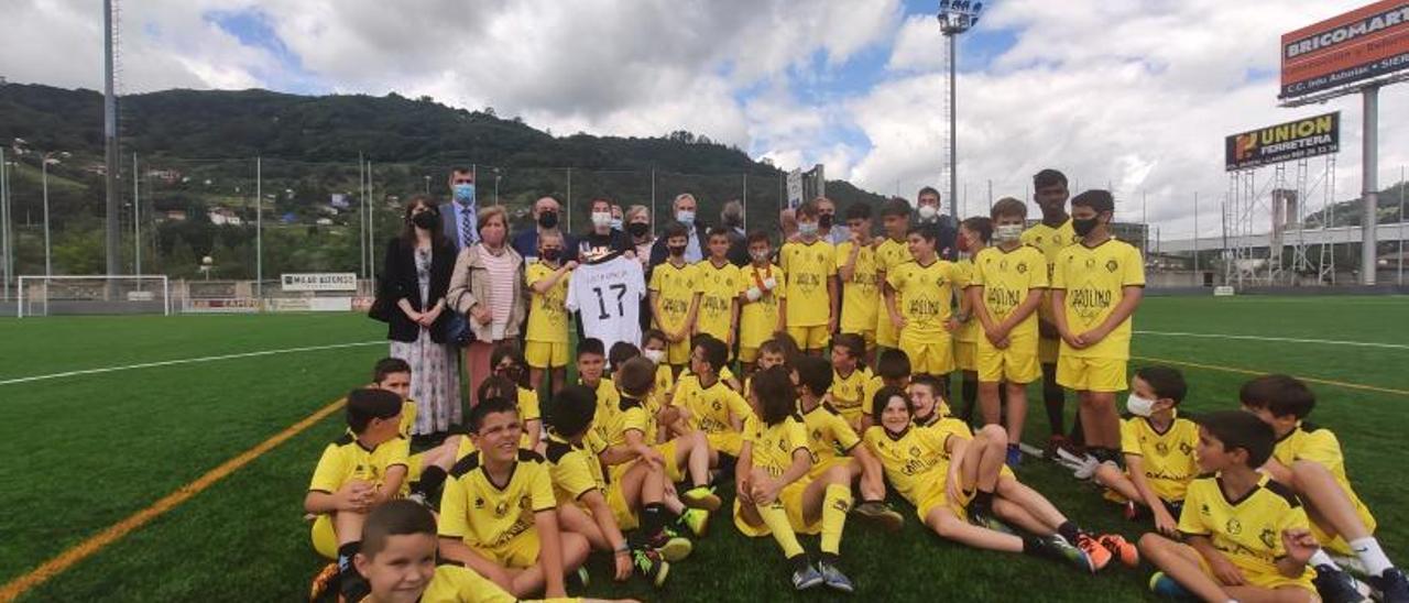 Lucía García, con los niños del campus del Caudal y los representantes de “Mierenses en el Mundo”, Ayuntamiento y de la entidad deportiva. | A. Velasco