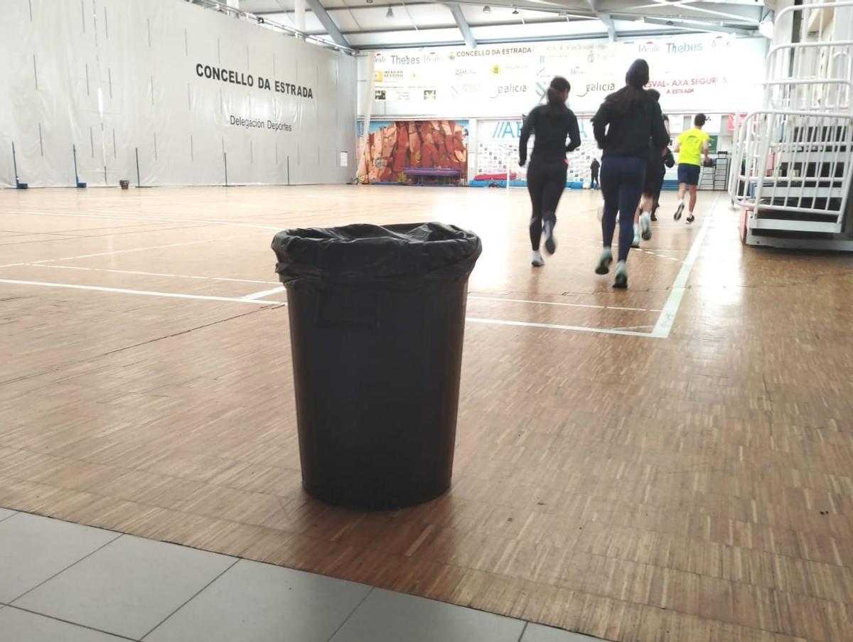 Deportistas del Atletismo A Estrada corren en una de las pistas entre cubos