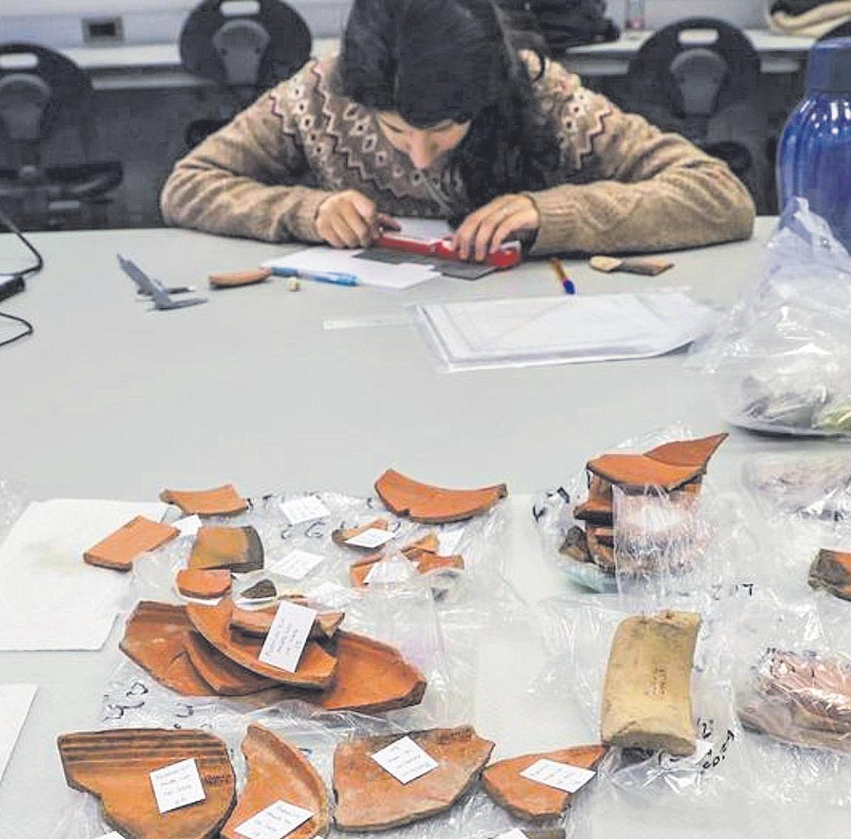 Investigadores examinan restos  de cerámica procedentes de una  excavación de la provincia.