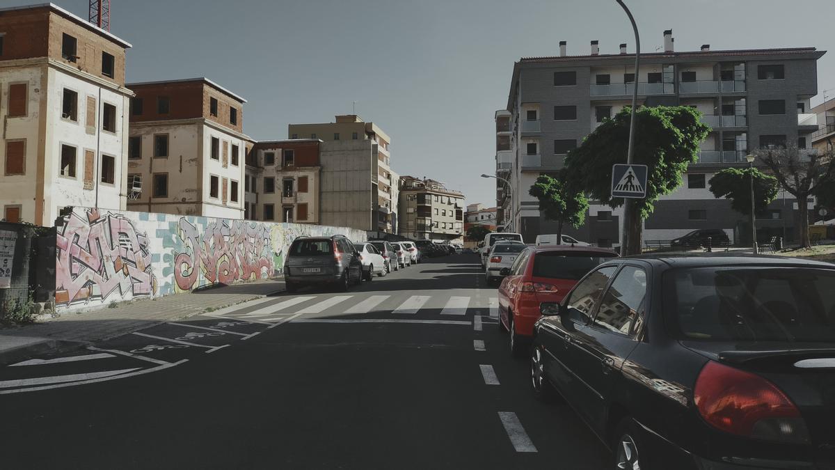 Muro de los pabellones, a la izquierda y zona verde, a la derecha, que se van a modificar en Plasencia.