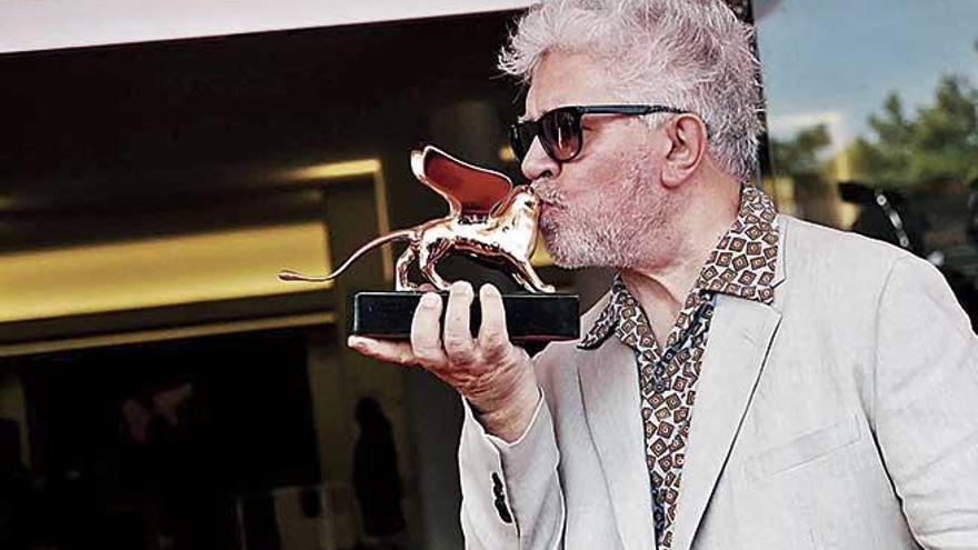 Pedro Almodóvar besa su León de Oro honorífico.