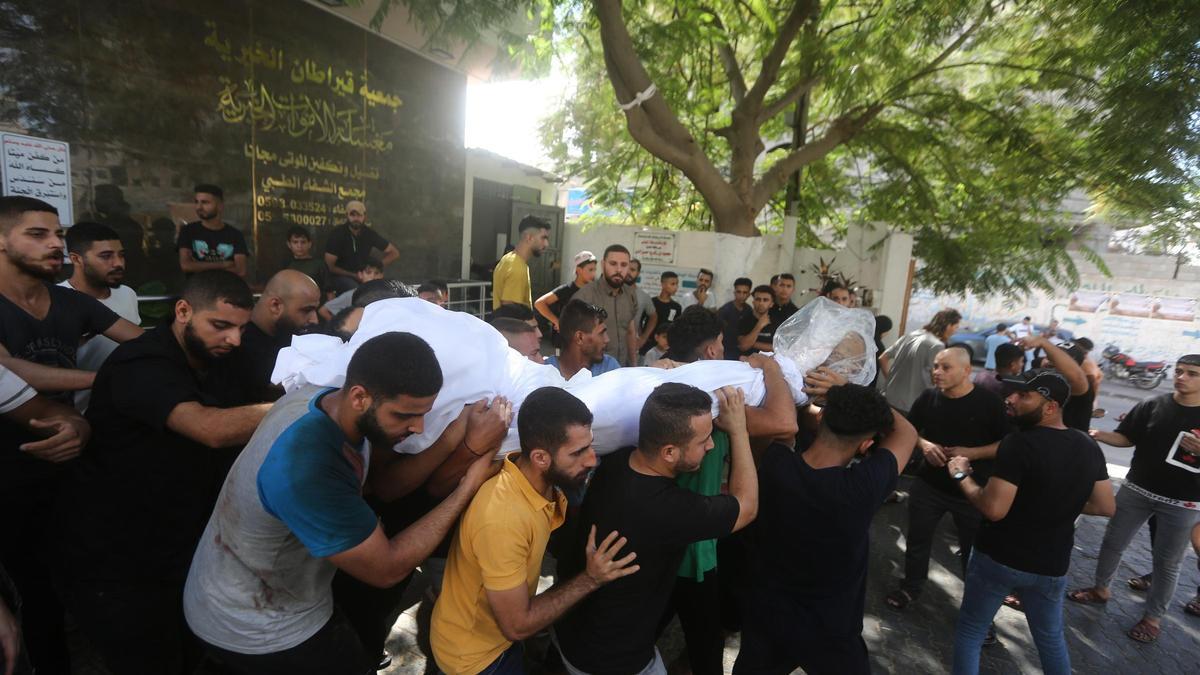 Palestinos trasladan los cuerpos de personas asesinadas por Israel, fuera del hospital Shifa en la ciudad de Gaza.