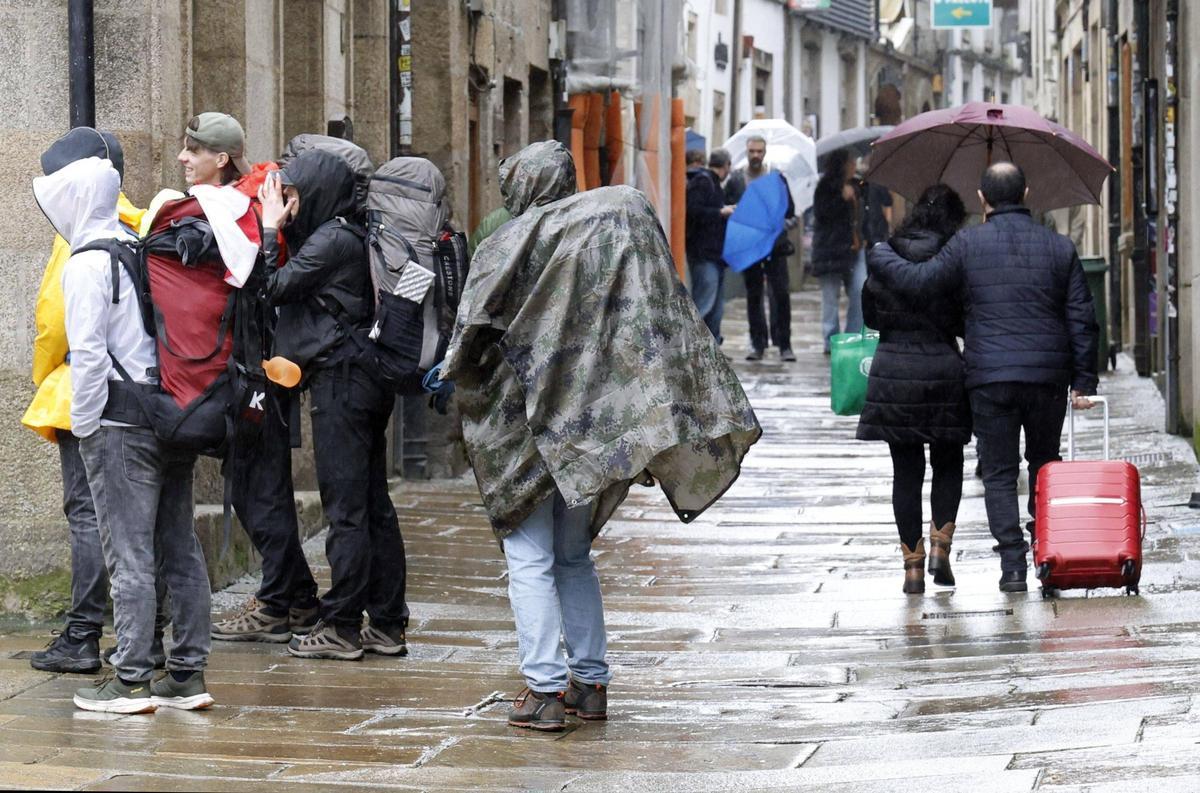 Turistas en las calles de Santiago durante una jornada lluviosa