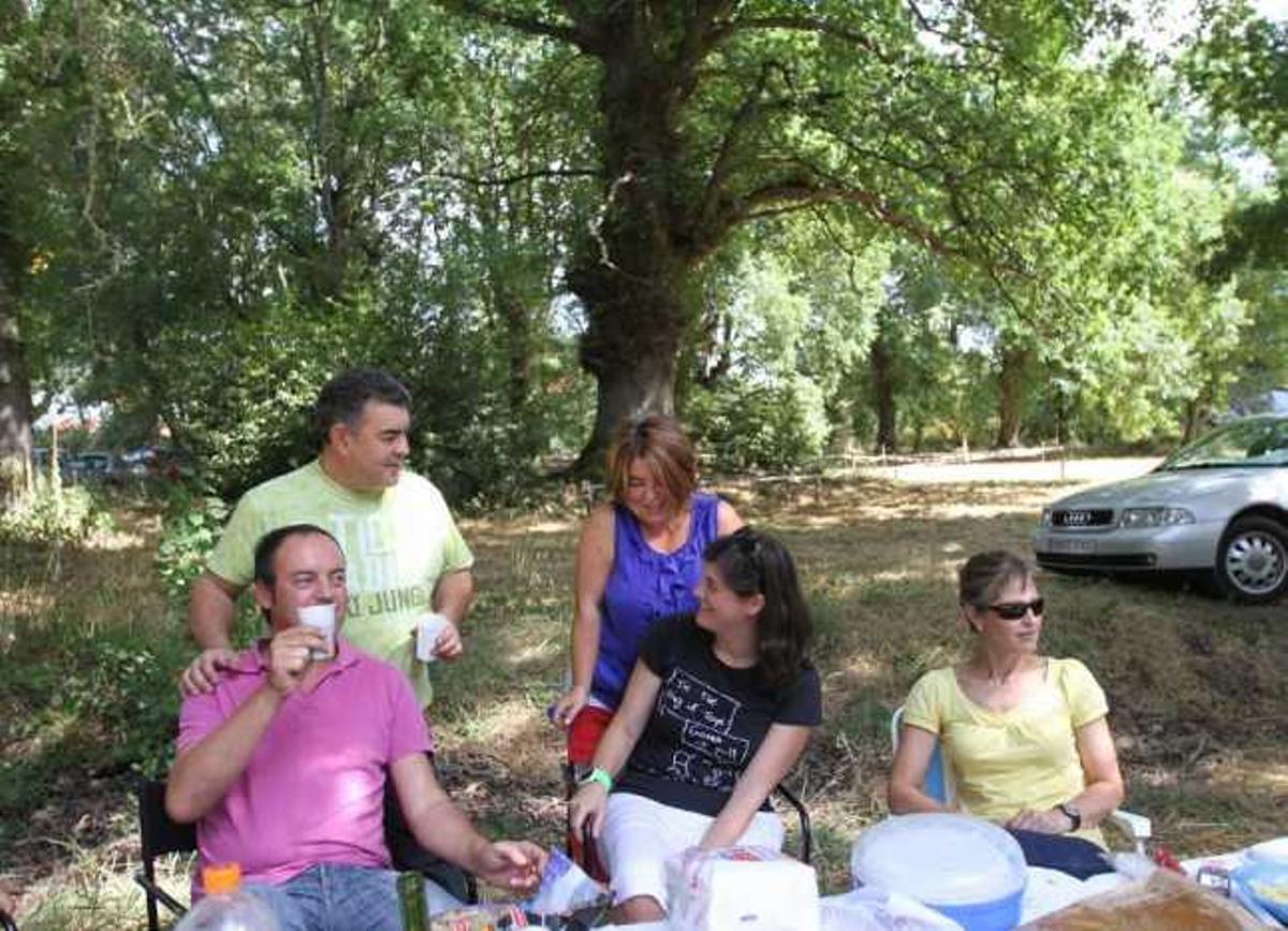 Una familia disfruta de la romería junto a la Carballa. // Iñaki Osorio