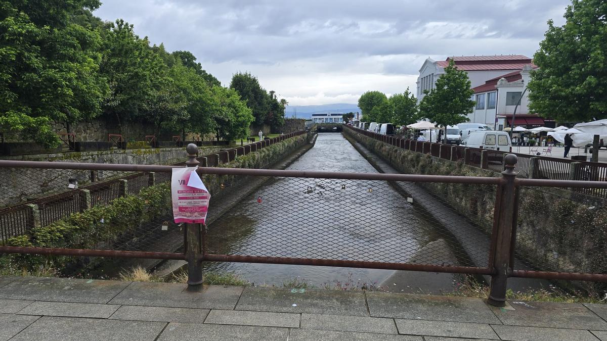 Carteles colgados en el puente de acceso a Vista Alegre sobre el río O Con.