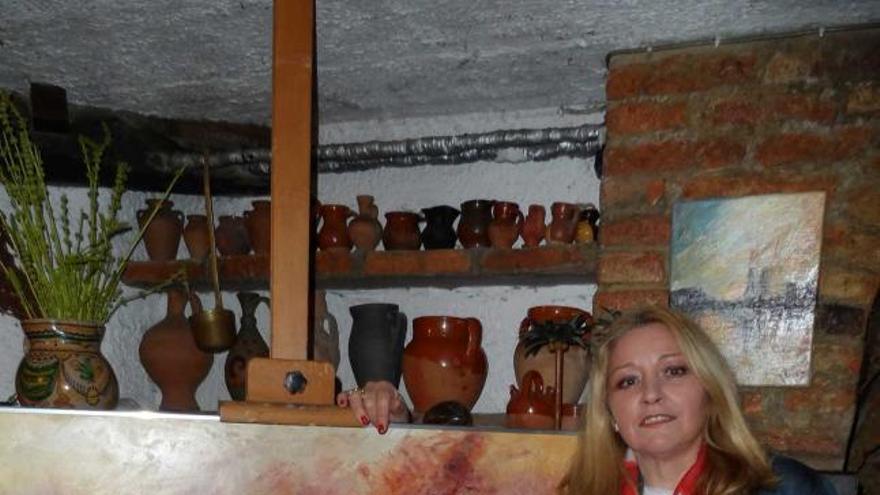 María Jesús Fernández, junto a una pintura y con uno de sus fulares.