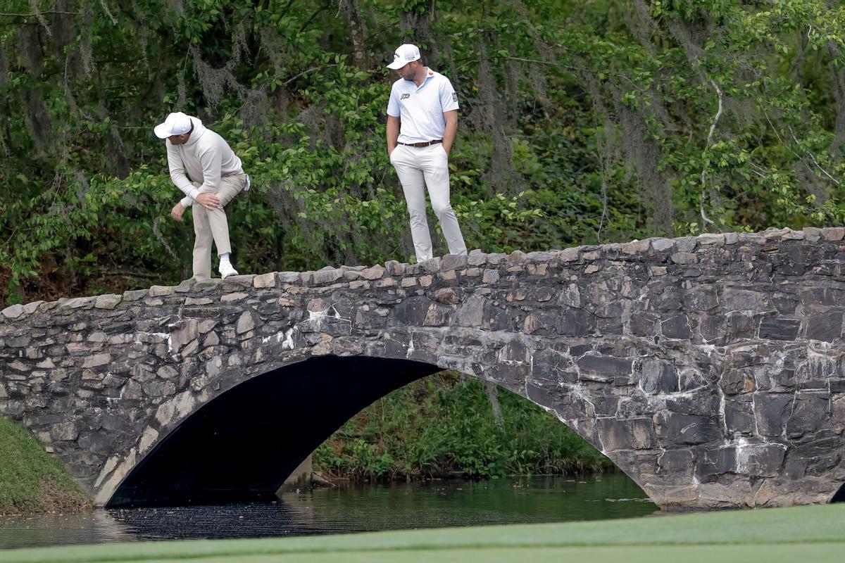 AUGUSTA (United States), 06/04/2026.- Scottie Scheffler (L) of the US and Sam Burns (R) of the US peer into Raes Creek from the Byron Nelson Bridge on the 13th hole during a practice round for the 2026 Masters Tournament at the Augusta National Golf Club in Augusta, Georgia, USA, 06 April 2026. The Masters golf tournament begins 09 April 2026. EFE/EPA/ERIK S. LESSER