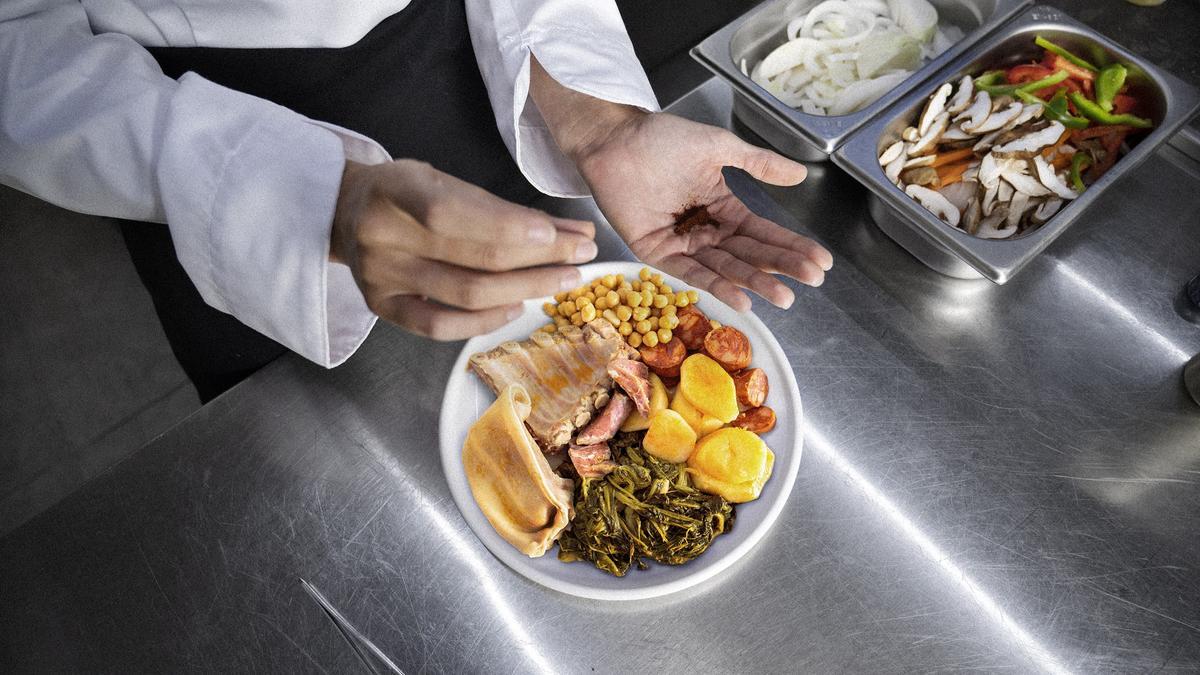 Un chef cocina sobre una encimera de acero inoxidable