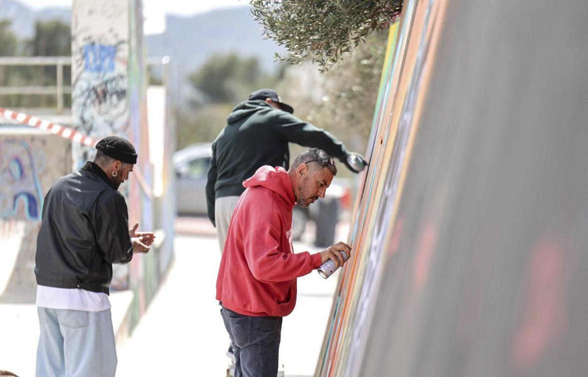 Algunos de los asistentes pintan un grafiti. | Toni Escobar | J.A. RIERA