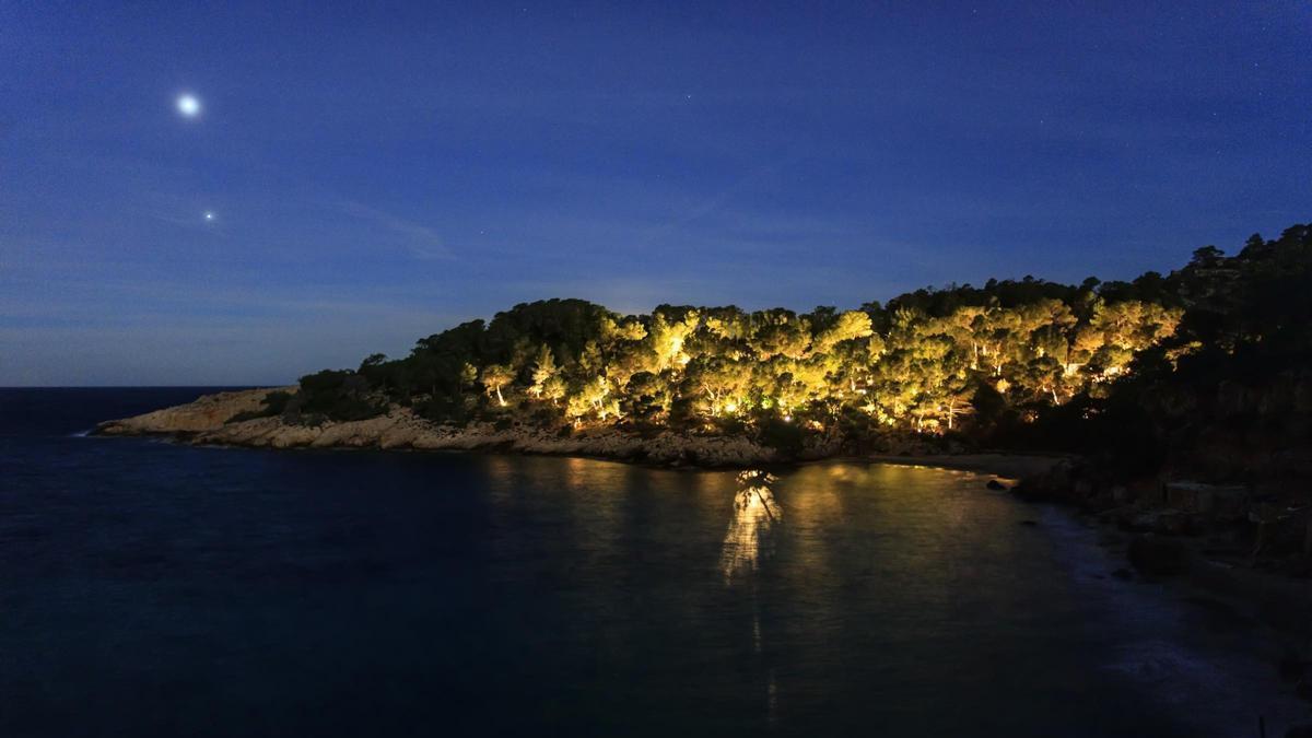 Una finca iluminada en Cala Saladeta durante la noche.