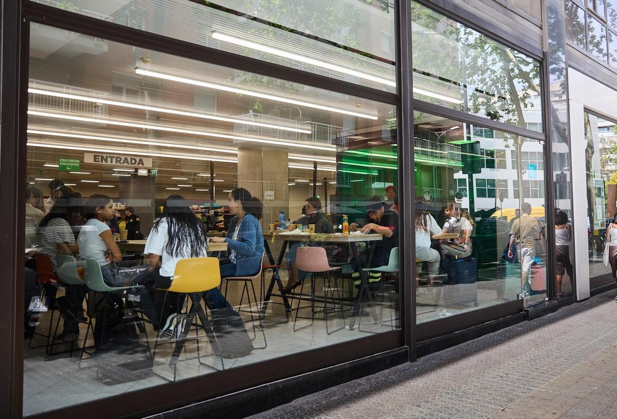 Zona para comer en la entrada de un supermercado de Barcelona denunciado administrativamente por el Gremi de Restauració.