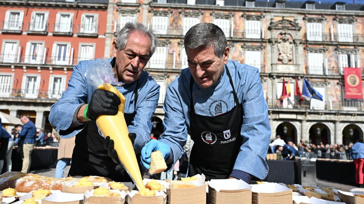 Reparto de la Corona de la Almudena gigante en la Plaza Mayor, organizado por ACYRE Madrid, en colaboración con el Ayuntamiento, este domingo.