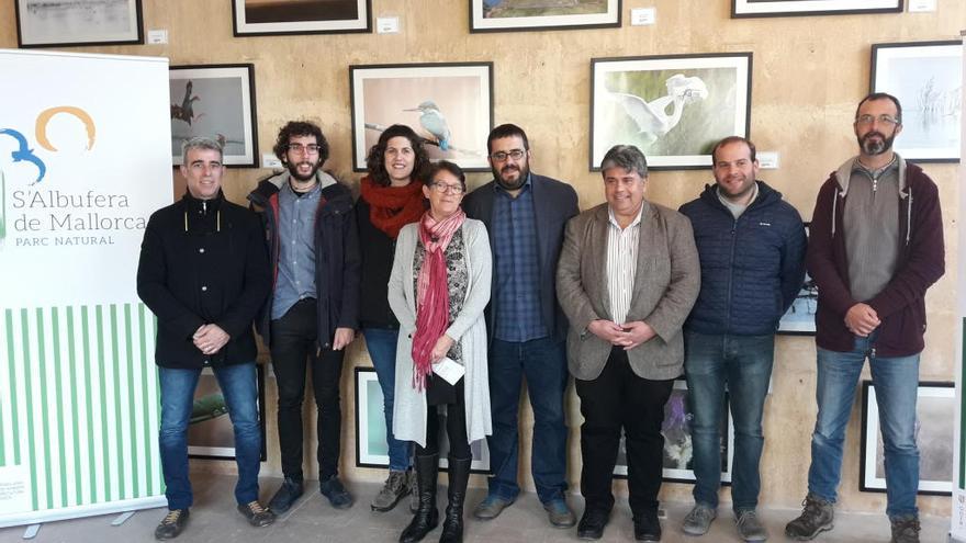 Autoridades y representantes del parque natural posan junto al nuevo logo y las fotografías de naturaleza.