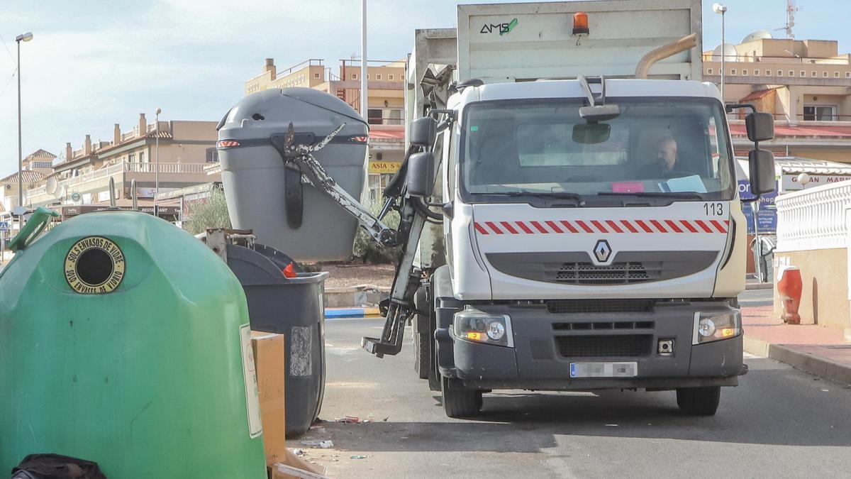 Un camión del servicio de recogida de basuras vacía un contenedor en Orihuela Costa.