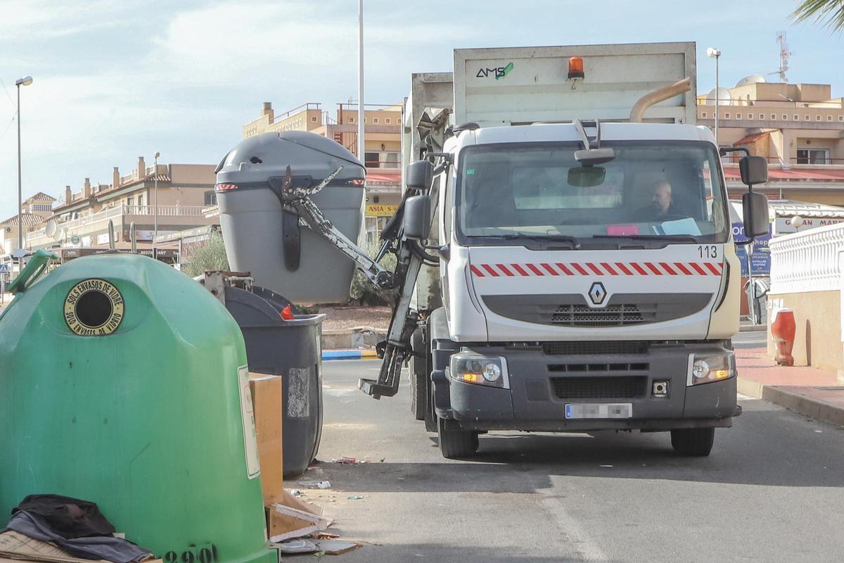 Un camión del servicio de recogida de basuras vacía un contenedor en Orihuela Costa.