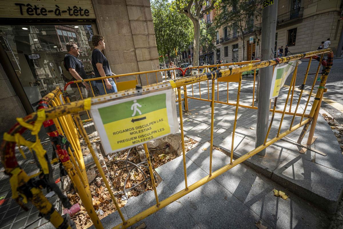 Personas duermen en la calle sobre colchones junto a comercios de la zona de Trafalgar-Méndez Núñez, a primera hora de la mañana. Comerciantes y vecinos denuncian la degradación del entorno y los continuos cortes de luz que afectan al barrio. A media mañana, la zona recupera su actividad habitual, con turistas y vecinos en las calles, tiendas y restaurantes abiertos y locales con carteles de «Se alquila», mientras en las aceras todavía pueden verse agujeros y obras de reparaciones recientes. Barcelona, 10 de agosto de 2026. Sociedad. AUTOR: MANU MITRU.